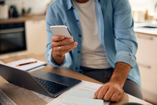 istock Close up of entrepreneur using cell phone while working at home. 2176488381