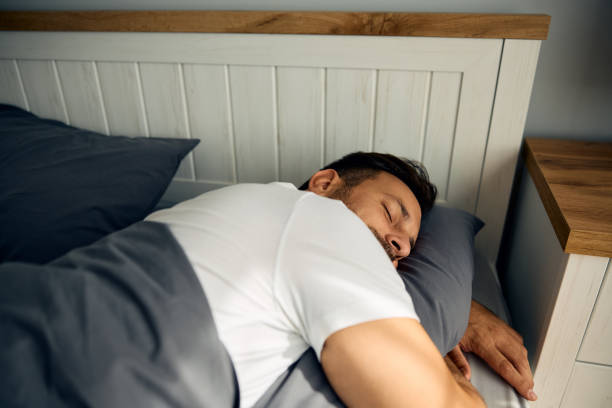 istock Carefree man sleeping on a bed. 2176490068