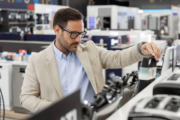 istock Man shopping for kitchen appliances in a modern retail store 2176492285