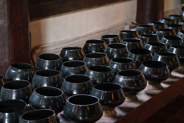 Black metal offering bowls for donations at a Buddhist temple in Thailand.