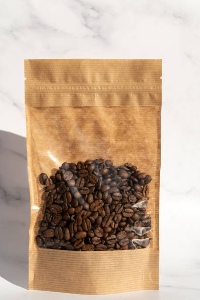 istock A kraft paper bag with coffee beans for viewing with a highlighted shadow lies on a white background 2176501565