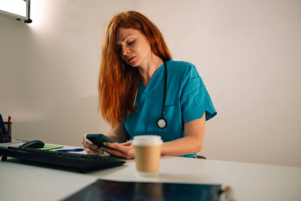 istock Physician using a smartphone while sitting in a medical office. 2176503032