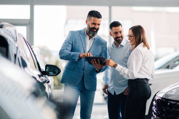 istock Collaborative decision-making with tablet in sunny dealership. 2176505382