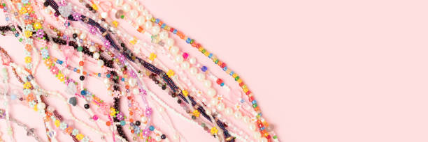 istock Chains of beads and natural stones on a pink background. 2176506544