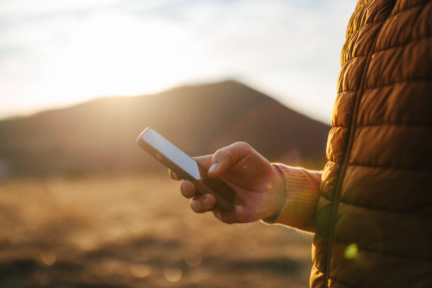 Person Using Smartphone During Mountain Vacation at Sunset