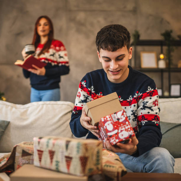 istock young man prepare Christmas gift with festive decorations at home 2176511520