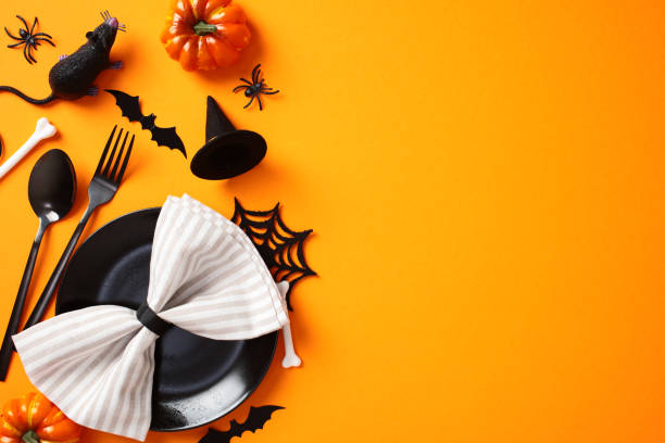 istock Halloween table setting on orange background. Flat lay black plate with napkin, cutlery, pumpkins, bats, spiders, rat 2176513170
