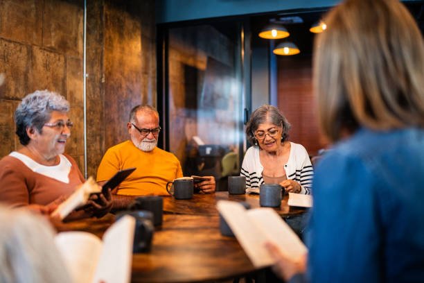 istock Senior friends on a reading book group at coffee shop 2176513622