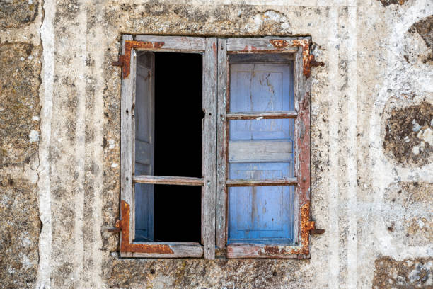 Picturesque rustic old window with wooden frames and blue shutters in a stone house, Galicia in Spain