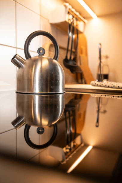 Kettle and reflection of kettle on electrical stove in the kitchen
