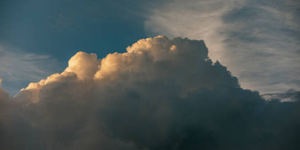 istock Large fluffy majestic clouds with sunset golden light and blue dramatic sky. Beautiful cloudscape for nature, weather, or backgrounds. Landscape photography. 2176522133