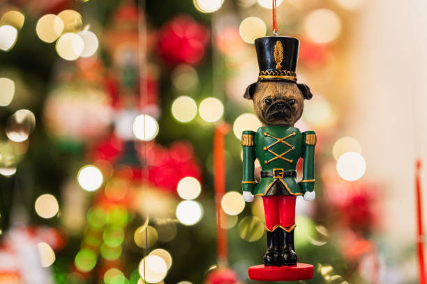 Nutcracker pug christmas ornament hanging on a christmas tree with bokeh lights