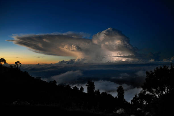 The early morning sunrise over the Perez Zeledon valley is very dramatic.  The formation contains several levels of clouds and colors.  The the very back of the photo you can see the pacific ocean.  There is lightning inside the top cloud formation.  The night lights of the city of Perez Zeledon are visible in the photo