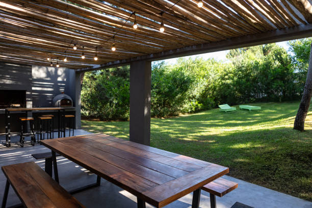 Hardwood rooftop patio deck with a picknick table and chairs as well as a bean bag chair. There is also a rooftop garden with plants.