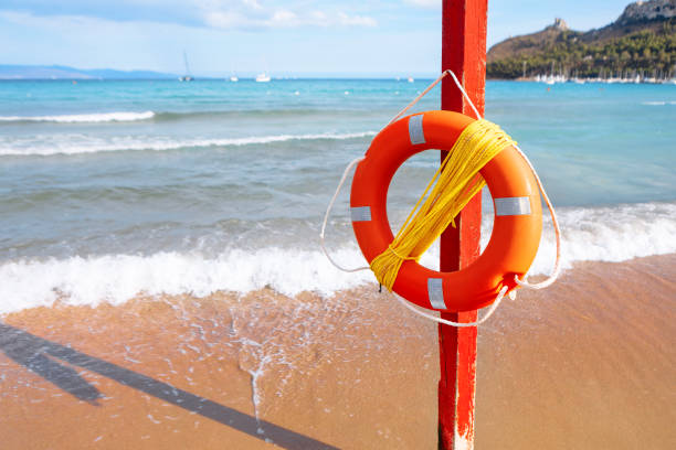Lifebuoy with rope mounted on a pole on the beach. Life preserver serving as a vital safety measure for beachgoers