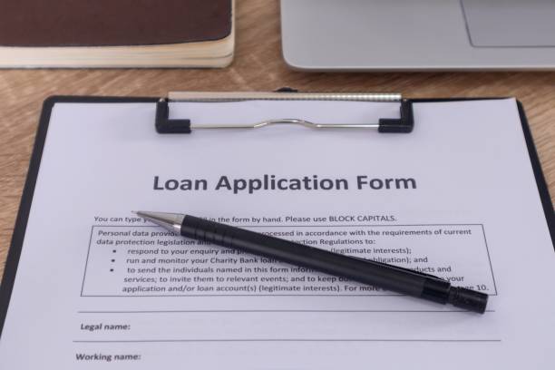 istock Loan application form on the wooden table with pen, laptop, and notebook. 2176555403