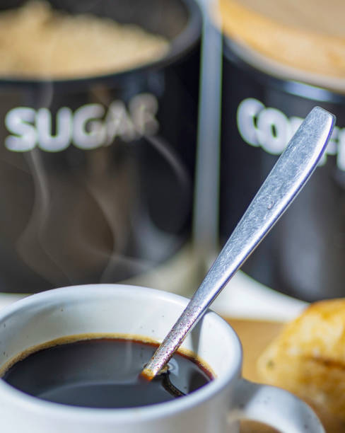 Hot Espresso coffee,in a small,white cup,with a teaspoon inside, just after stirring,Worcestershire,United Kingdom.