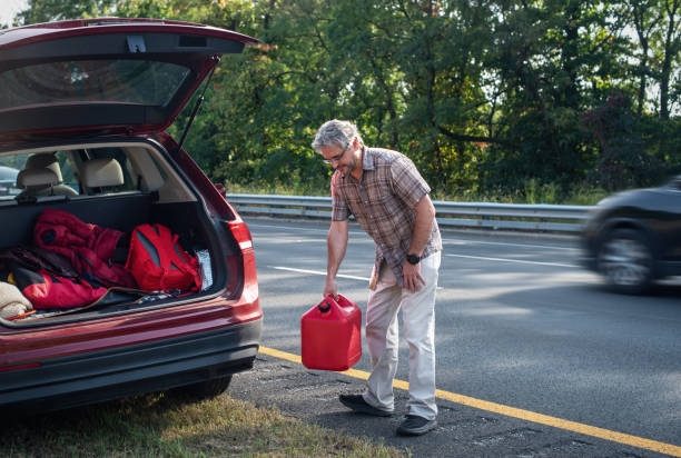 istock Unexpected pit stop. Middle-aged man refuels stranded vehicle on highway shoulder 2176565713