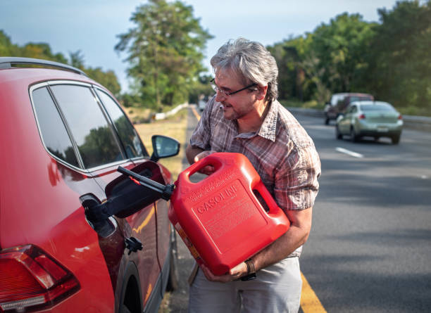 istock Fuel emergency solved. 53-year-old man refills red car on highway shoulder 2176565717