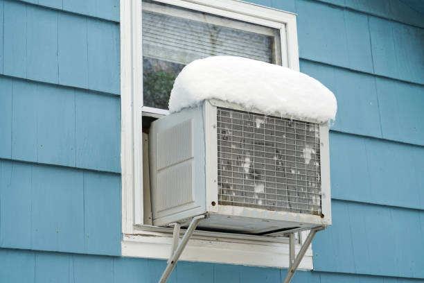 istock old air conditioner installed on house window after winter snow 2176581807