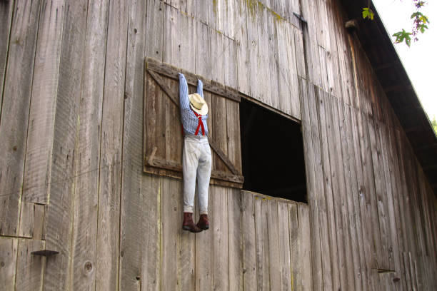 Red rustic wooden barn facade and stone foundation with white window
