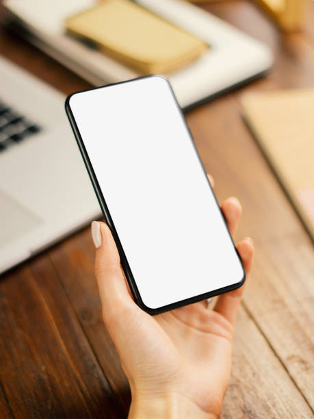 istock Mockup image of a woman using smartphone with blank screen on wooden table 2176584987