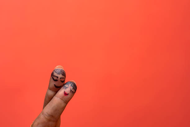 Creative concept photo of two fingers decorated as a couple hugging, symbolizing love, romance, and togetherness. Ideal for Valentines Day, relationships, and emotional connections.
