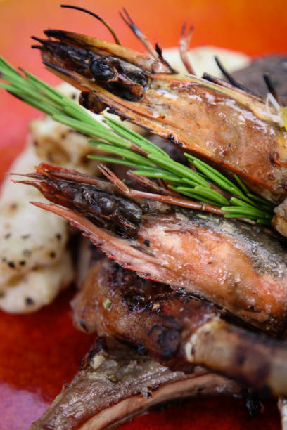 istock Plate serving beach bbq seafood with fish, prawns and squid in sunny beach restaurant in Maldives 2176592020