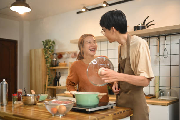 istock Young couple enjoying a lighthearted moment while preparing a meal together in kitchen 2176594336