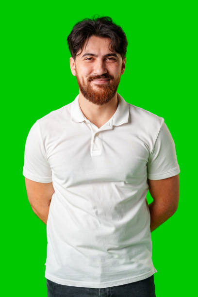 istock A smiling young man with a beard poses against a bright green background 2176594888