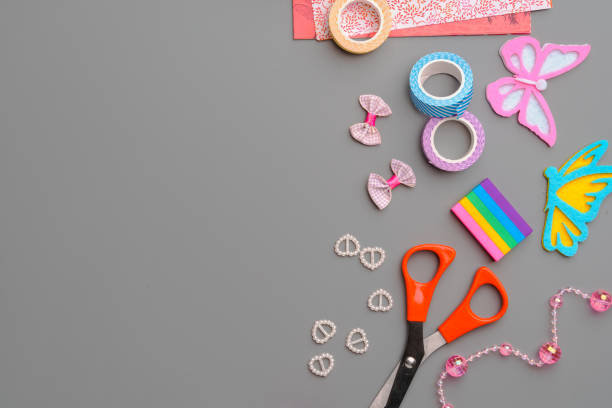 istock Crafting supplies arranged for a DIY project on a gray table with scissors, washi tape, and decorative items 2176594893