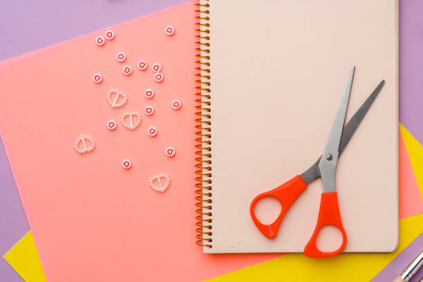 istock Scissors and decorative tape on colorful craft paper in a bright workspace 2176594897