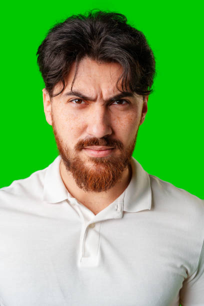 istock A young man with a beard showing a serious expression against a vibrant green background 2176597162
