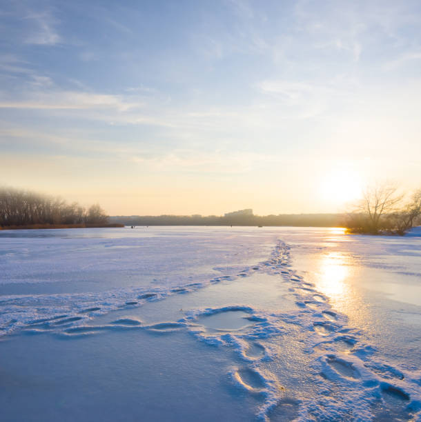 frozen lake at the sunset, quiet evening winter river landscape