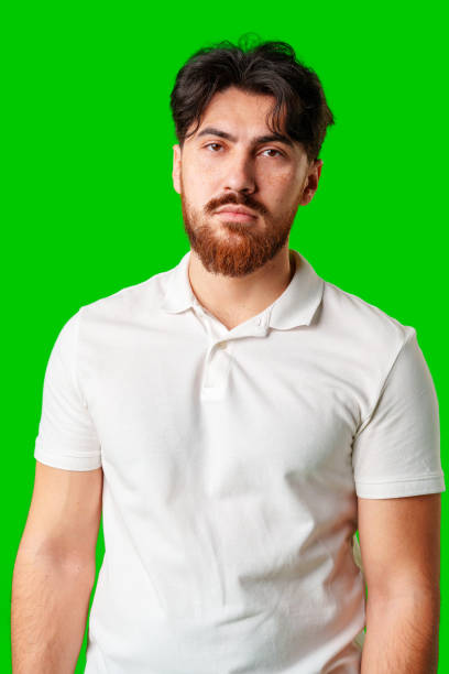istock A man with a serious expression stands against a vibrant green background 2176598377