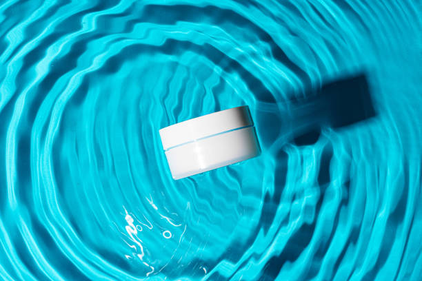 istock Sunscreen bottle floating in a clear blue swimming pool on a sunny day 2176598381