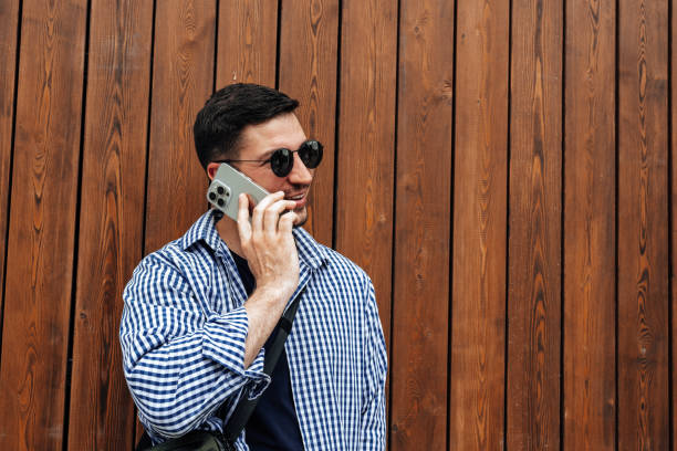 Man in sunglasses smiling while talking on his phone close up