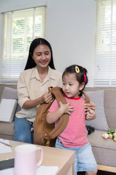 istock Morning Routine Mother Assisting Daughter with Backpack for School 2176601428