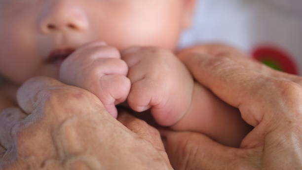 istock A mother holding a baby hands. 2176601497