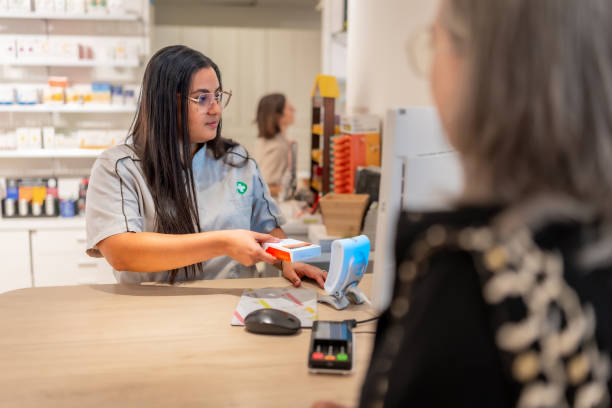 istock Pharmacist checking the price of a product attending a client 2176603144