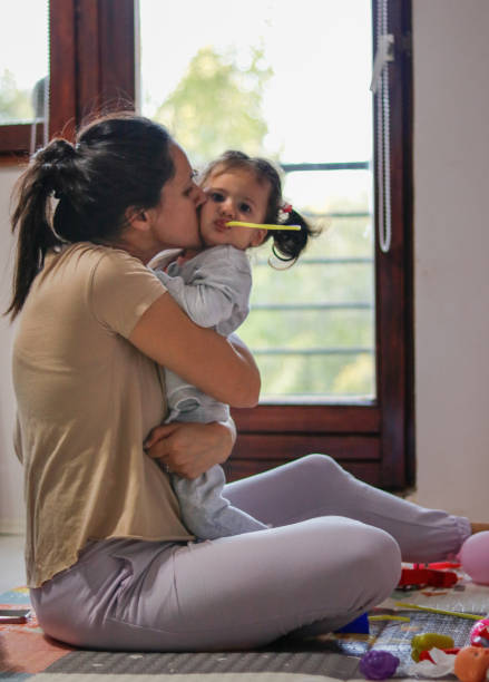 istock mother kissing daughter while watching cartoons 2176603848