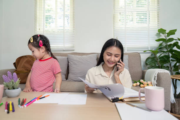 istock Multitasking Mother Managing Work Calls with Active Daughter Nearby 2176604086