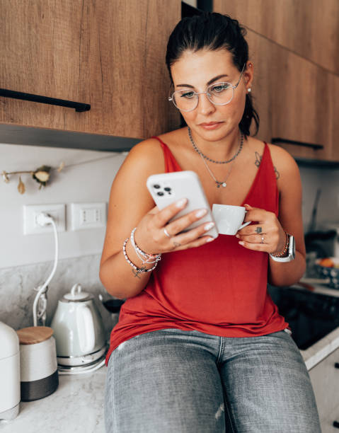 coffee break at home in the kitchen reading the smartphone