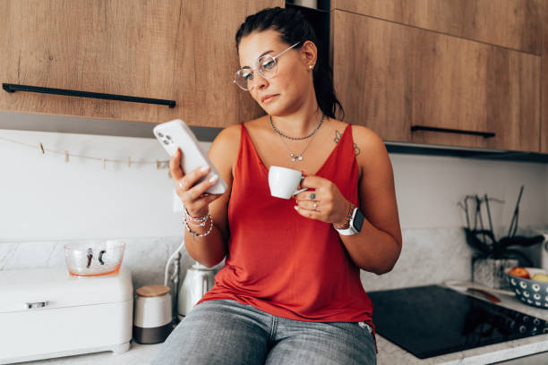 istock coffee break at home in the kitchen reading the smartphone 2176606036