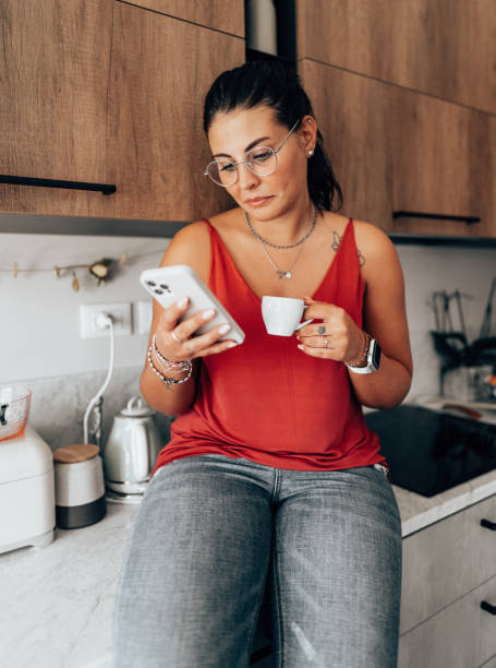 istock coffee break at home in the kitchen reading the smartphone 2176606123
