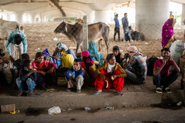 New Delhi, India-May 21, 2020: Migrant worker families stopped by police, waiting to cross the interstate border during lockdown.