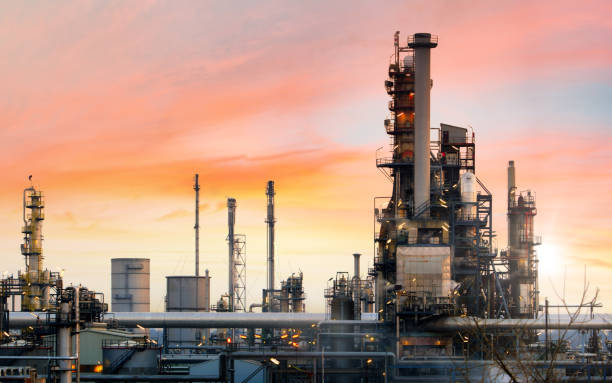 Oil refinery and plant and tower column of Petrochemistry industry in oil and gas industrial with cloud orange sky the sunrise background stock photo