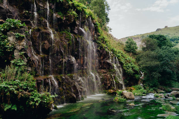 istock A waterfall in a canyon cascades down steep cliffs surrounded only by green foliage at midday 2176616248