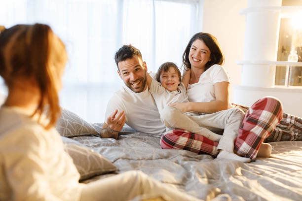 istock Happy family talking during morning on a bed. 2176619434