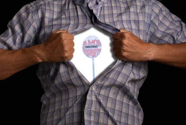 Man tears open his shirt, exposing sign with inscription Sanctions inside, symbolizing restrictions and prohibitions